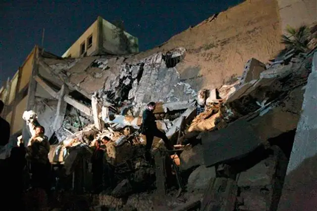 Libyan soldiers survey the damage to an administrative building hit by a missile late Sunday in the heart of Moammar Gadhafi's Bab Al Azizia compound in Tripoli, Libya, early Monday
